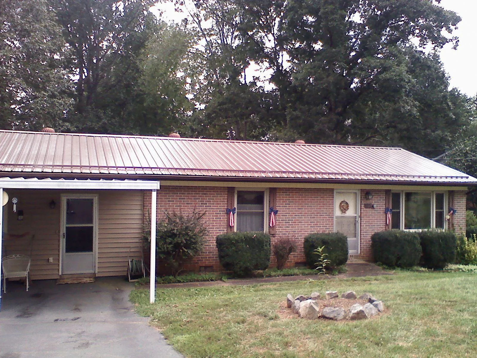 Bronze metal roof and carport on a brick ranch home — Roof Repair work by our crew in Terrebonne