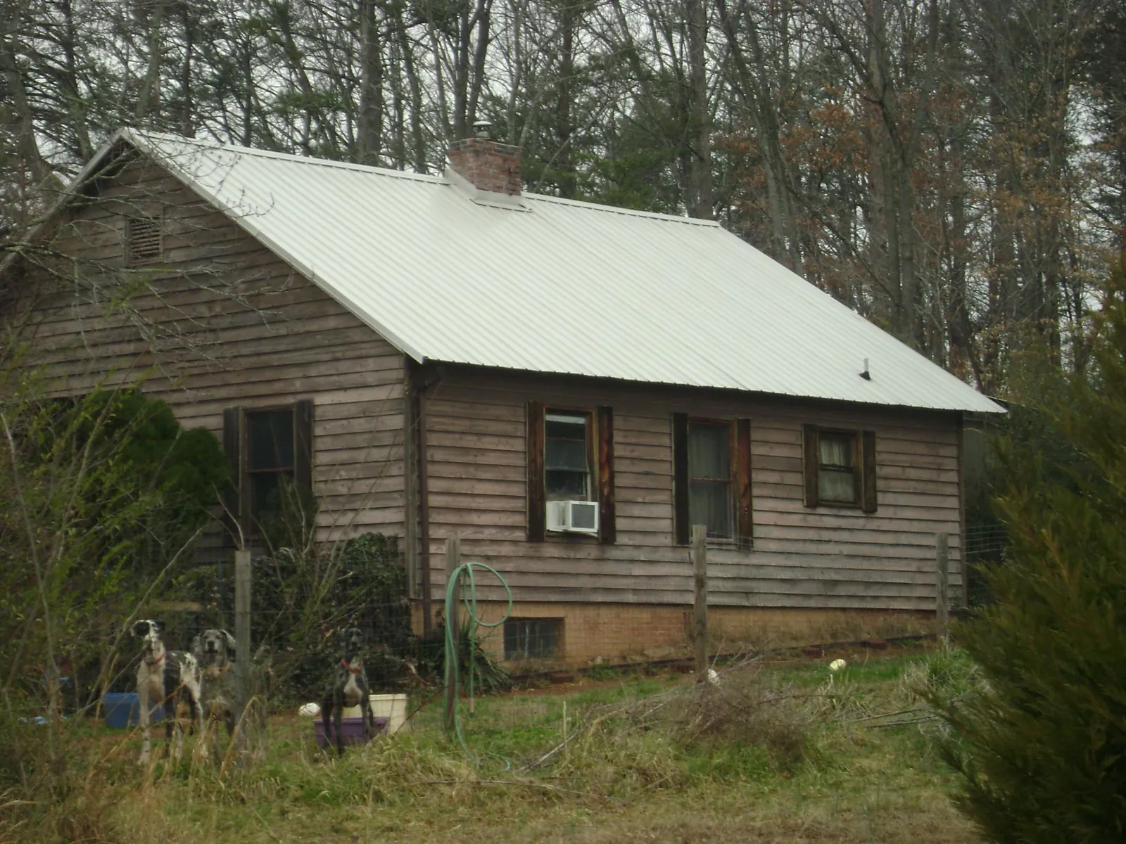 White metal roof on an old wood sided farmhouse, from a Asphalt Shingle Roof Repair job in Terrebonne